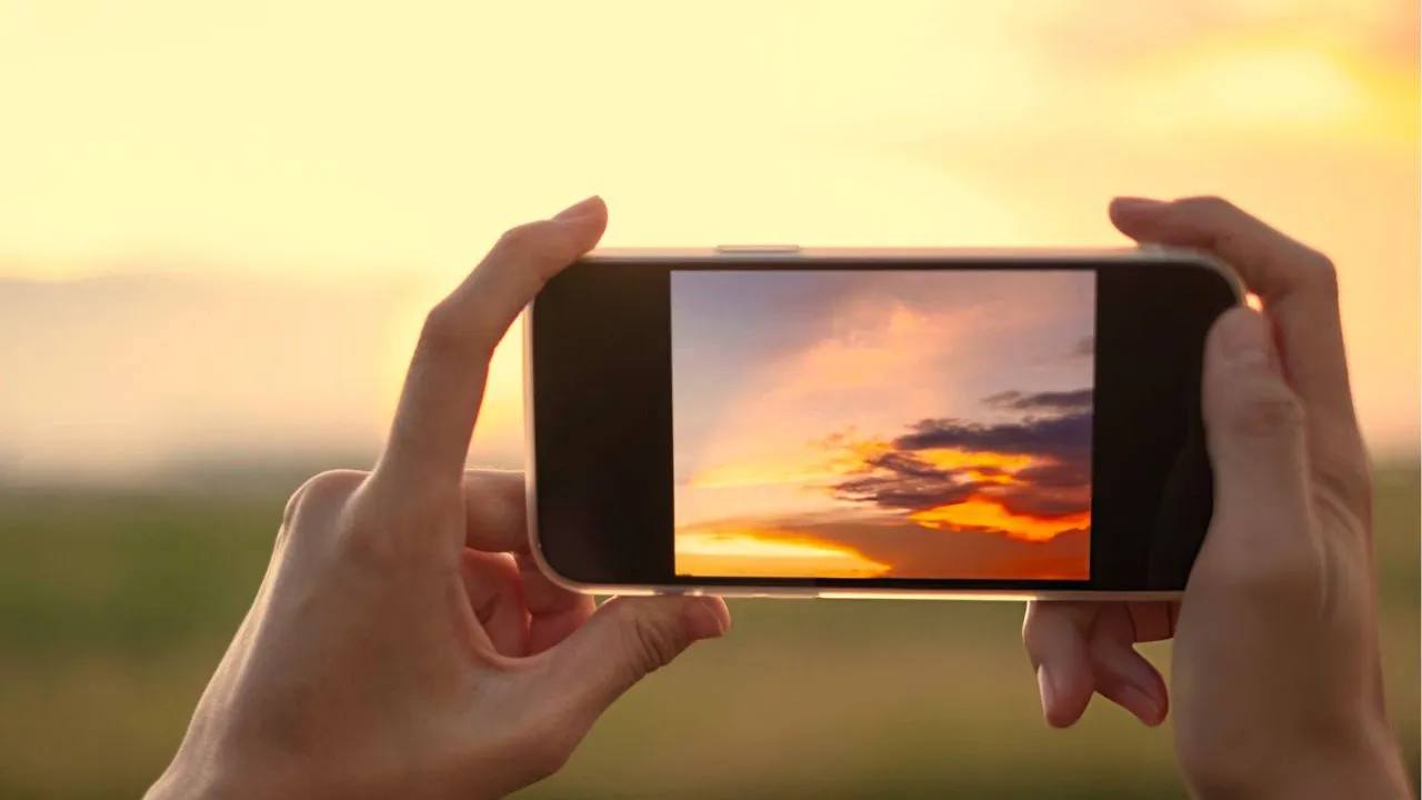 Image of someone's hands holding a Samsung 5G smartphone and clicking pictures using the phone's camera